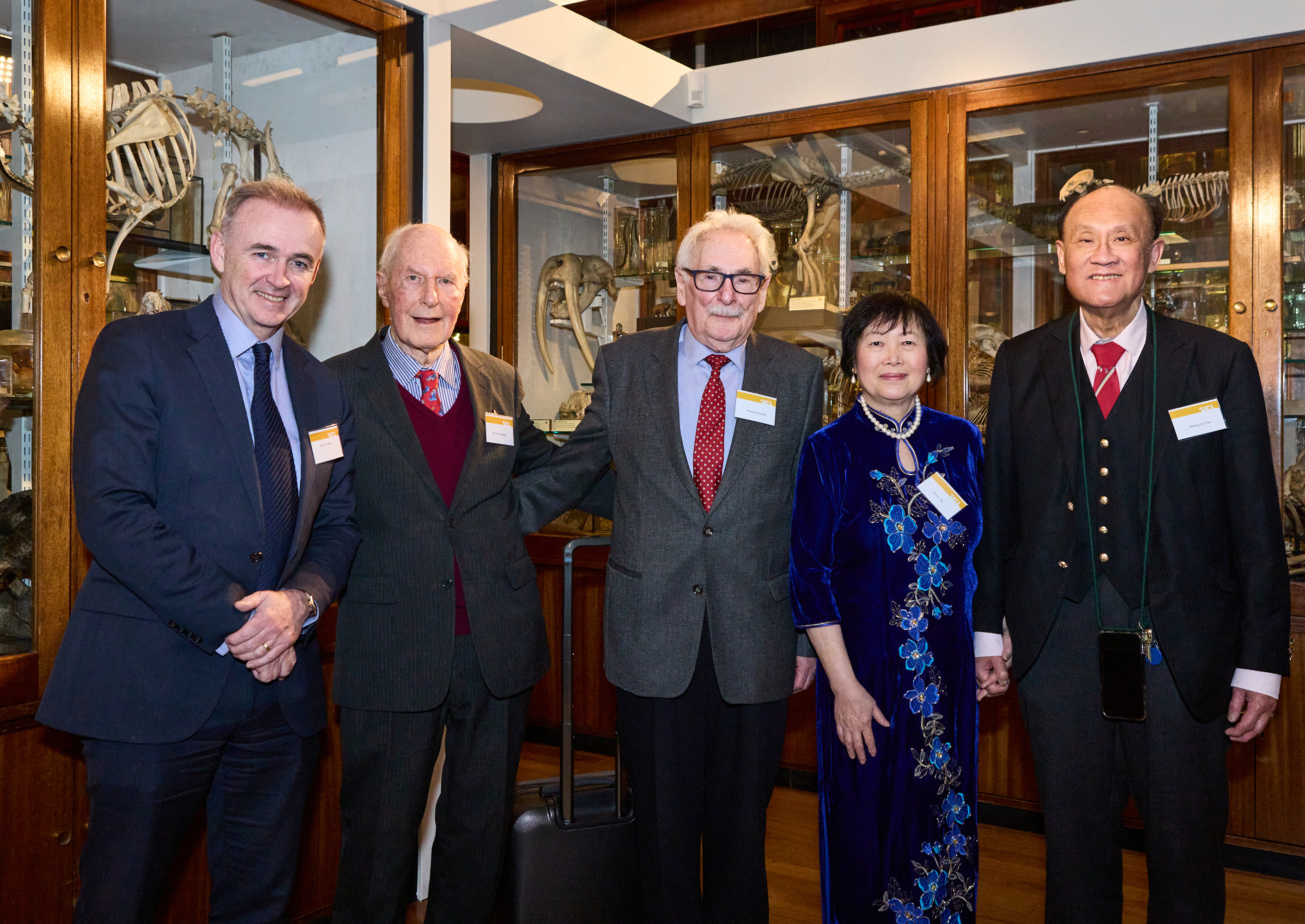 Doctor Grace Tan and Professor Seang Lin Tan with three UCL staff in a wood-panelled exhibition room at UCL.